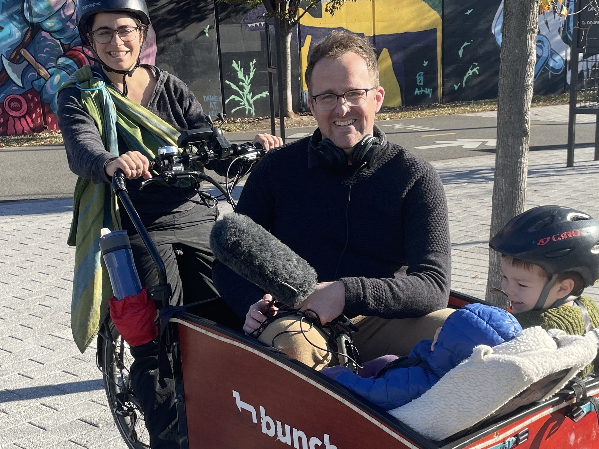 caption: Lelac Almagor and two of her children take NPR's Adam Bearne for a ride in their e-cargo bike.