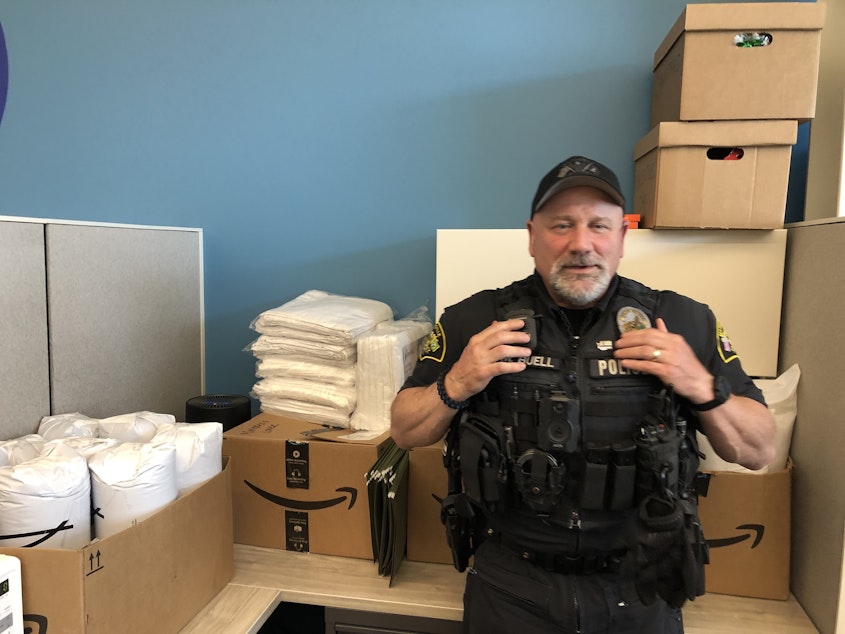 caption: Marysville Police Officer Mike Buell with the bedding and other supplies that his team provides to people when they secure housing. 