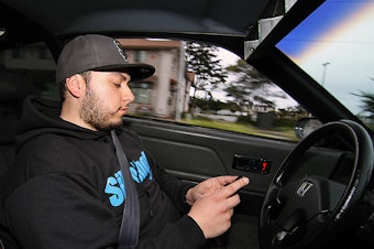 caption: Having a phone in your hand while driving could cost you $136 under the new law.