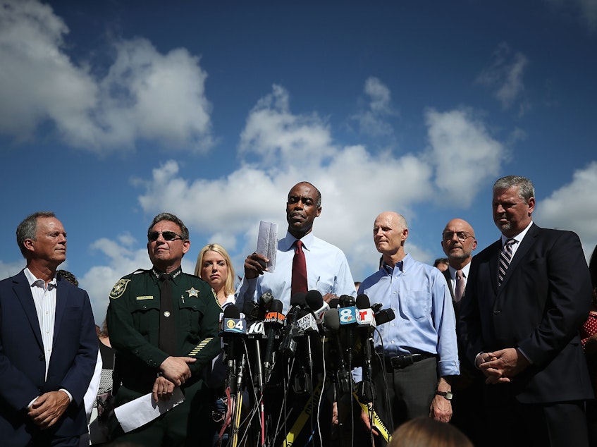 caption: Broward County Public Schools Superintendent Robert Runcie (center) speaks to media in February in Parkland, Fla., the day after the shooting at Marjory Stoneman Douglas High School. He is flanked by Broward County Sheriff Scott Israel (left) and Florida Gov. Rick Scott (right).
