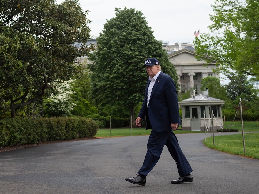 caption: President Trump walks to the White House on Sunday, after returning from Camp David in Maryland.