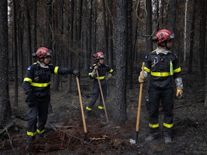 caption: Canada is in the midst of an unprecedented wildfire season, intensified by climate change. Firefighters came from all over the world to help, like this team from France, on the fire line north of Chibugamau, Quebec, in June.