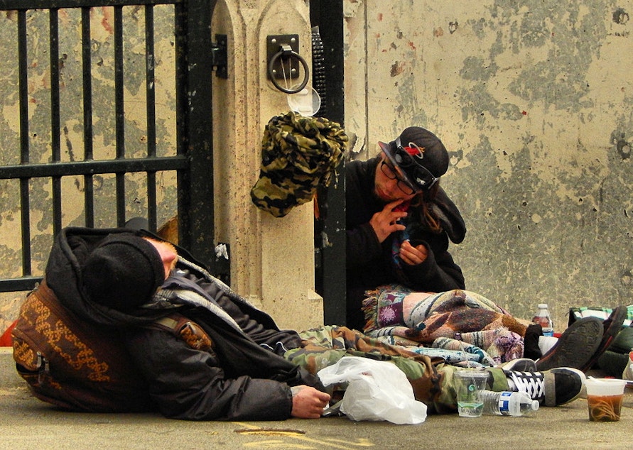caption: Two people experiencing homelessness in Seattle's University District.