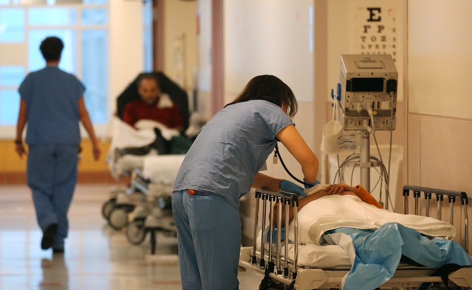 caption: A medical student checks on a patient in the hallway of the emergency room at Harborview Medical Center Wednesday, March 12, 2003, in Seattle.