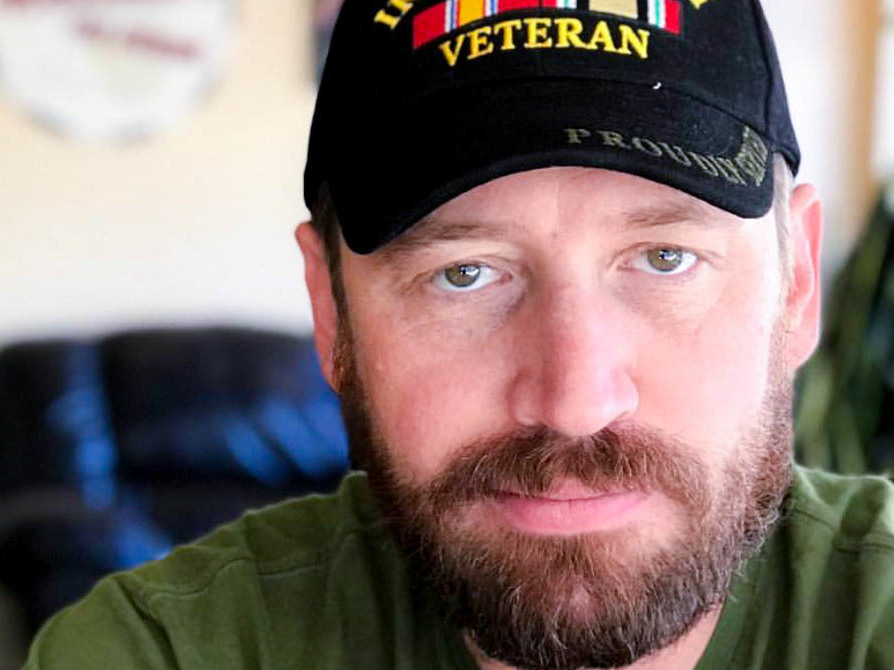 caption: "I think in a lot of ways, we survived that deployment in Iraq by sharing humor with each other," said former Army Spc. Garett Reppenhagen, seen at home in Colorado Springs, Colo.