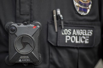 caption: A Los Angeles police officer wears an Axon body camera in 2017. On Thursday, the company announced it is holding off on facial recognition software, citing its unreliability.