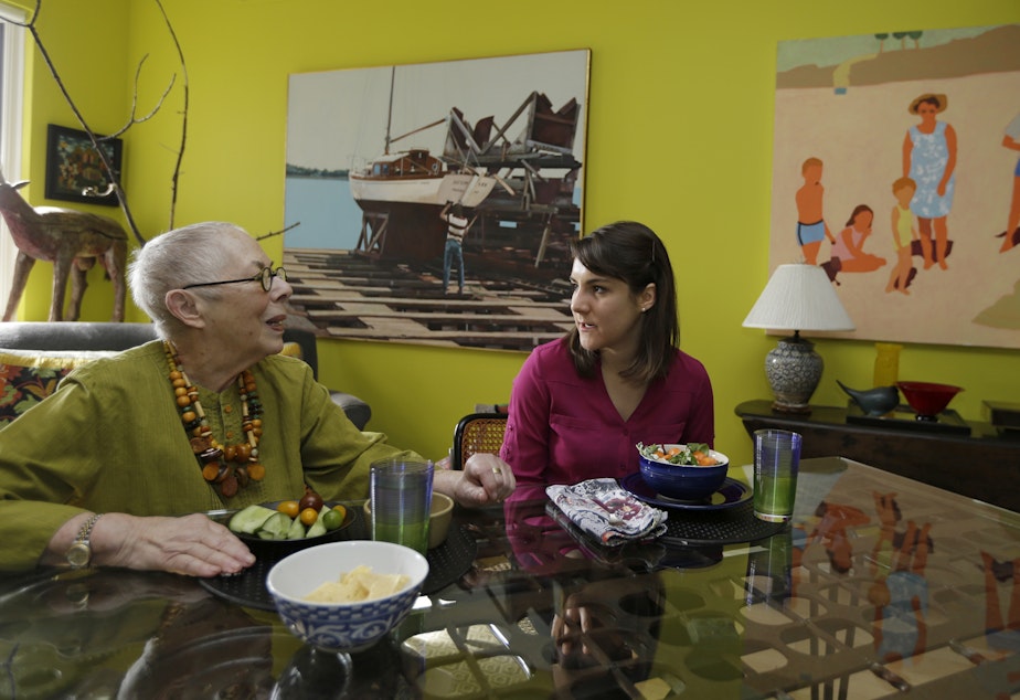 caption: Laura Berick, left, a retired art dealer, has lunch with Justine Myers at Berick's home in Judson Manor, in Cleveland, Feb. 17, 2017. (Tony Dejak/AP)