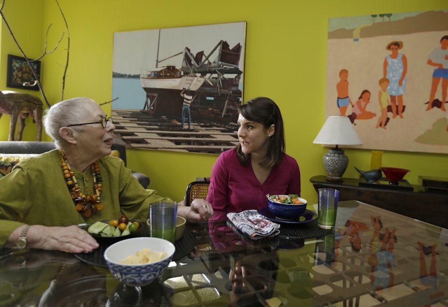 caption: Laura Berick, left, a retired art dealer, has lunch with Justine Myers at Berick's home in Judson Manor, in Cleveland, Feb. 17, 2017. (Tony Dejak/AP)