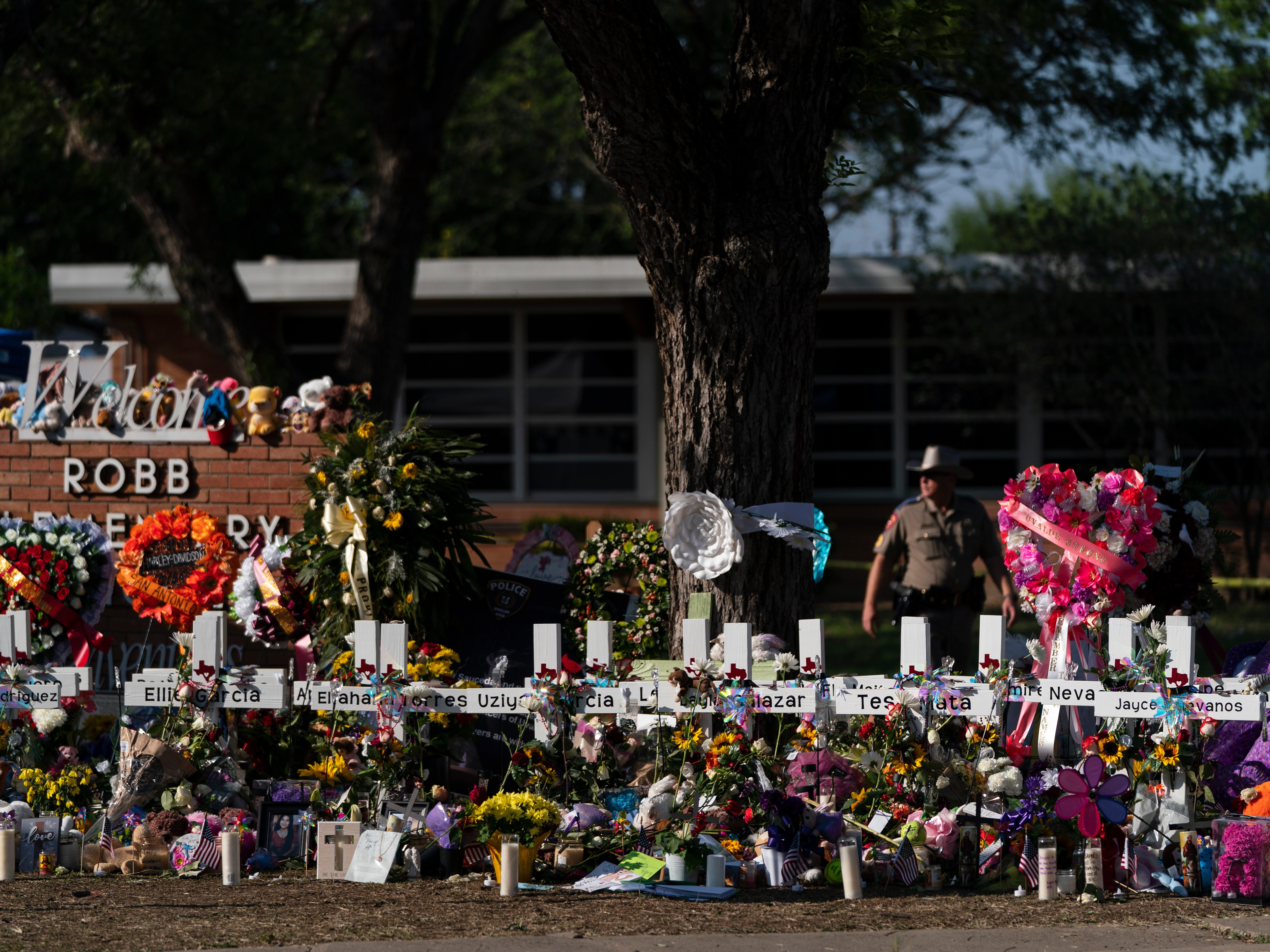 caption: Flowers and candles are placed around crosses to honor the victims killed in a school shooting, May 28, 2022, outside Robb Elementary School in Uvalde, Texas.