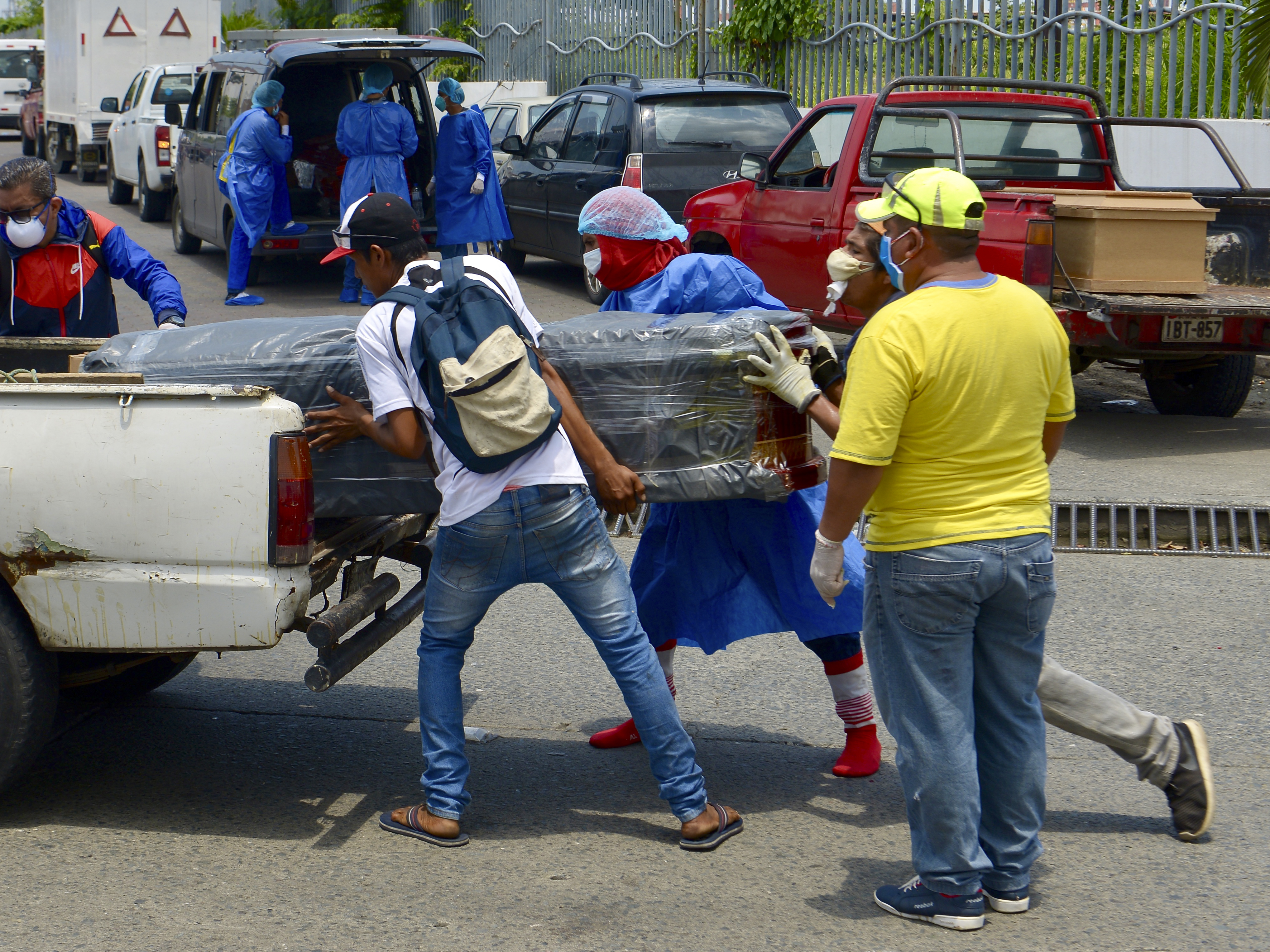 caption: Men load a coffin onto a pickup truck in front of General del Guasmo Sur Hospital in Guayaquil, Ecuador. The port city is the most affected by COVID-19 in the country. Corpses lie in apartments for days and morgues are overcrowded. The city administration requested four refrigerated containers in which the corpses can be temporarily stored.