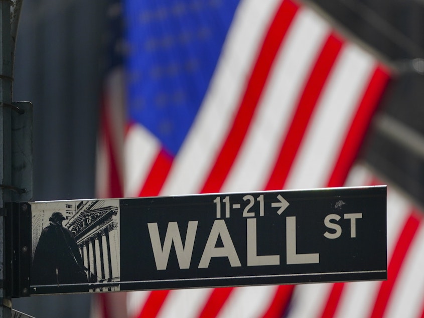 caption: The U.S. flag hangs outside the New York Stock Exchange earlier this month. Investors have been grappling with a wave of uncertainty that's sent the market lower in recent weeks.