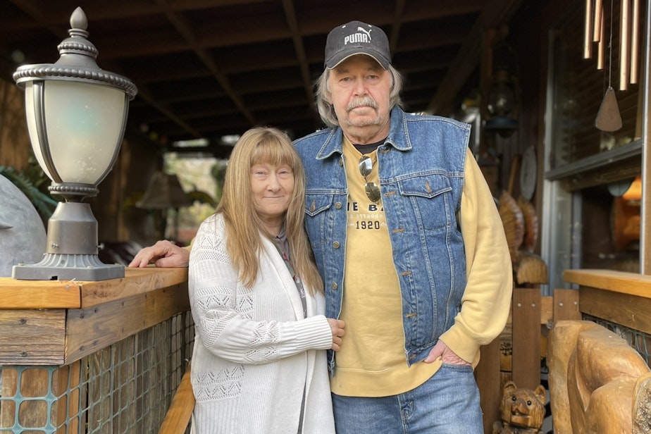 caption: Tom and Patty Gilbert outside their mobile home in Carnation, Washington.