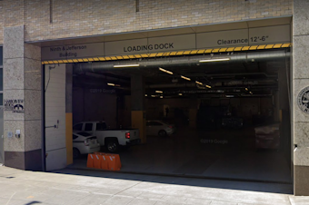 caption: The garage entrance to the building that houses the King County Medical Examiner's Office in downtown Seattle. The Medical Examiner's Office has been testing the bodies of some deceased since the coronavirus outbreak, focusing on those with Covid-19 symptoms. Roughly a quarter of those tests have come back positive. 