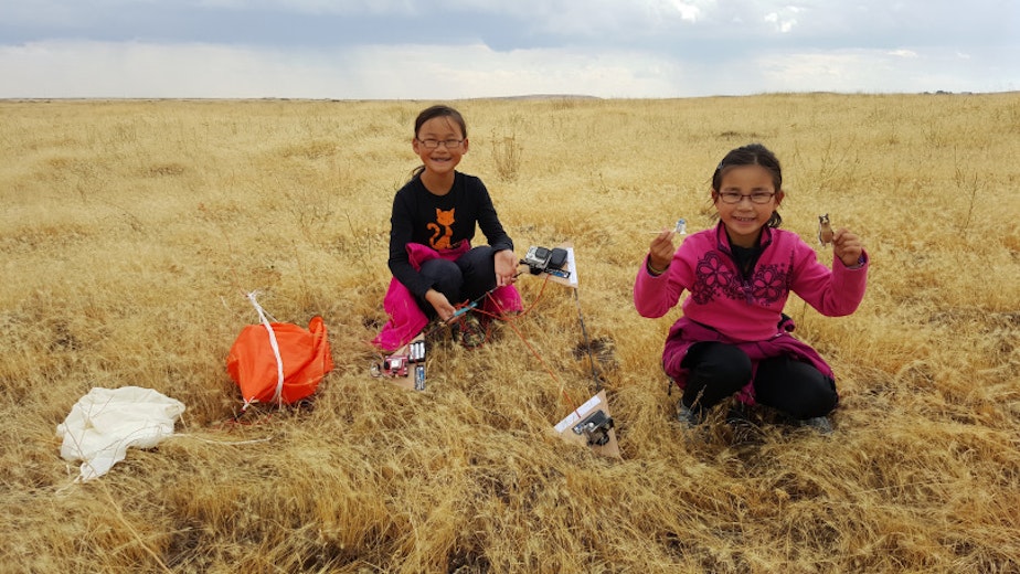 caption: Rebecca Yeung (left), and Kimberly Yeung retrieve the Loki Lego Launcher outside Ritzville, WA, after the ballooncraft returned from the stratosphere.