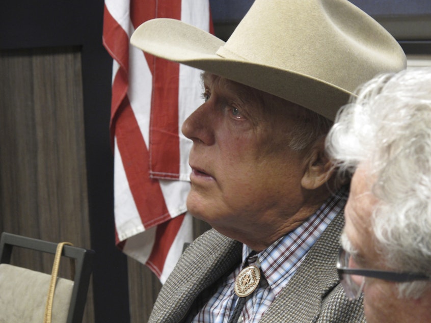 caption: Cliven Bundy listens to other speakers before giving the keynote address to the state convention of the Independent American Party of Nevada, in February 2018.