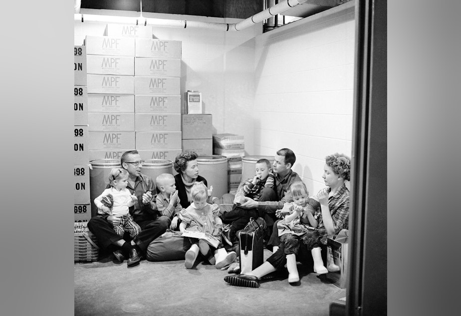 caption: In this Jan. 29, 1962 file photo, the Spalding family, left, and the Richmond family demonstrate how people of the town would sit out a nuclear attack and its radioactive aftermath in Los Alamos, N.M., birthplace of the atomic and hydrogen bombs.