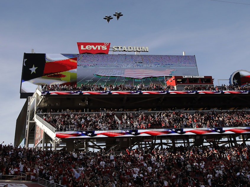 caption: Military planes fly over Levi's Stadium on Thursday during the playing of the national anthem. A cheerleader took a knee during the pre-game anthem, and may be the first NFL cheerleader to do so.