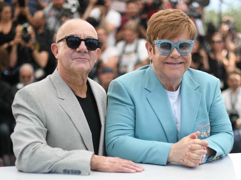 caption: Elton John and Bernie Taupin promote the film <em>Rocketman</em> at the Cannes Film Festival in 2019.