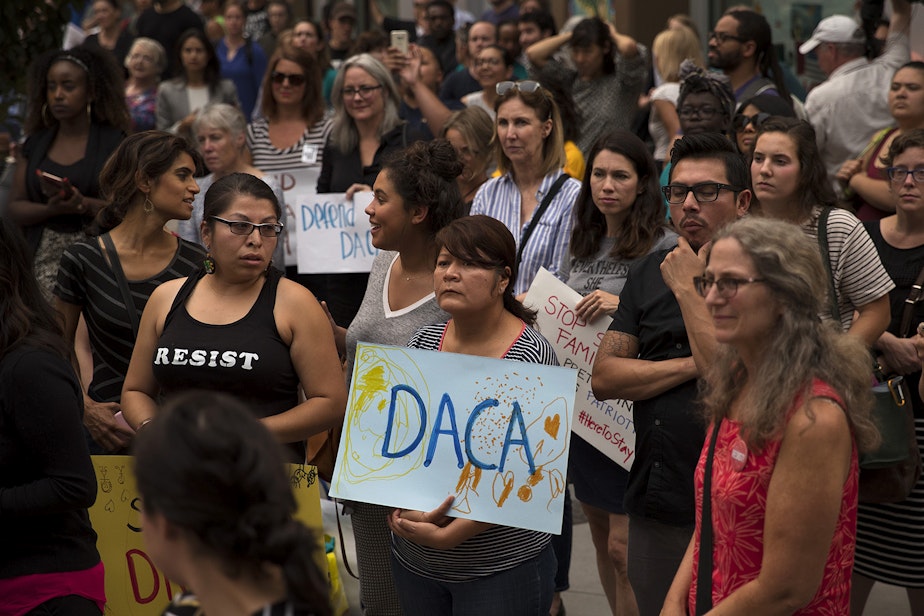 caption: A crowd gathers during a community rally in support of DACA recipients on Tuesday, September 5, 2017, at El Centro De La Raza in Seattle. 