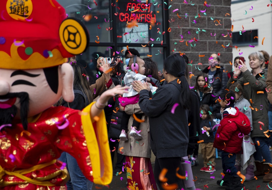 caption: Confetti falls as the Mak Fai Dragon and Lion dancers perform outside of Crawfish King during the Lunar New Year celebration on Saturday, Feb. 4, 2023, in Seattle’s Chinatown-International District. 
