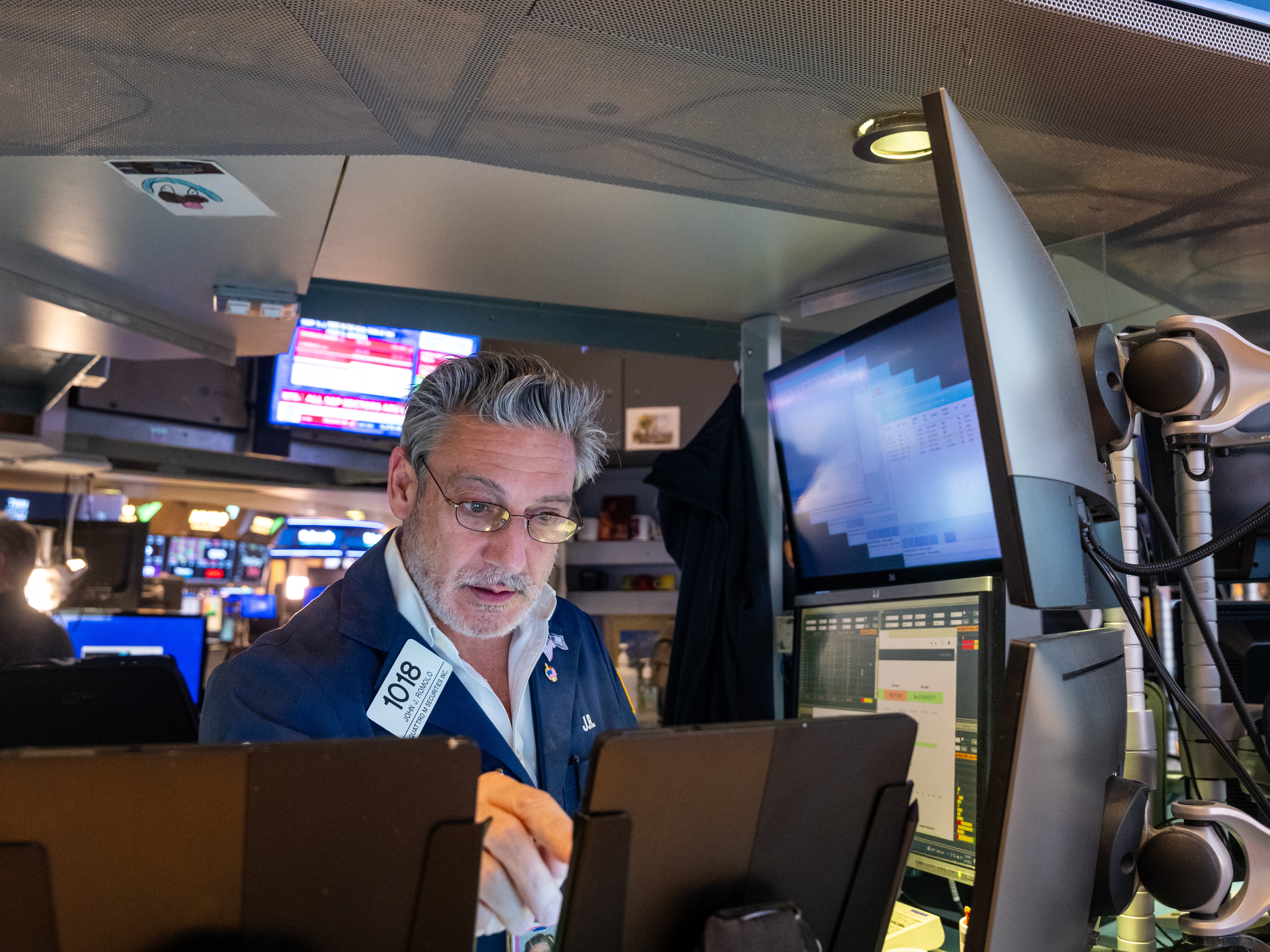 caption: A trader on the floor of the New York Stock Exchange.