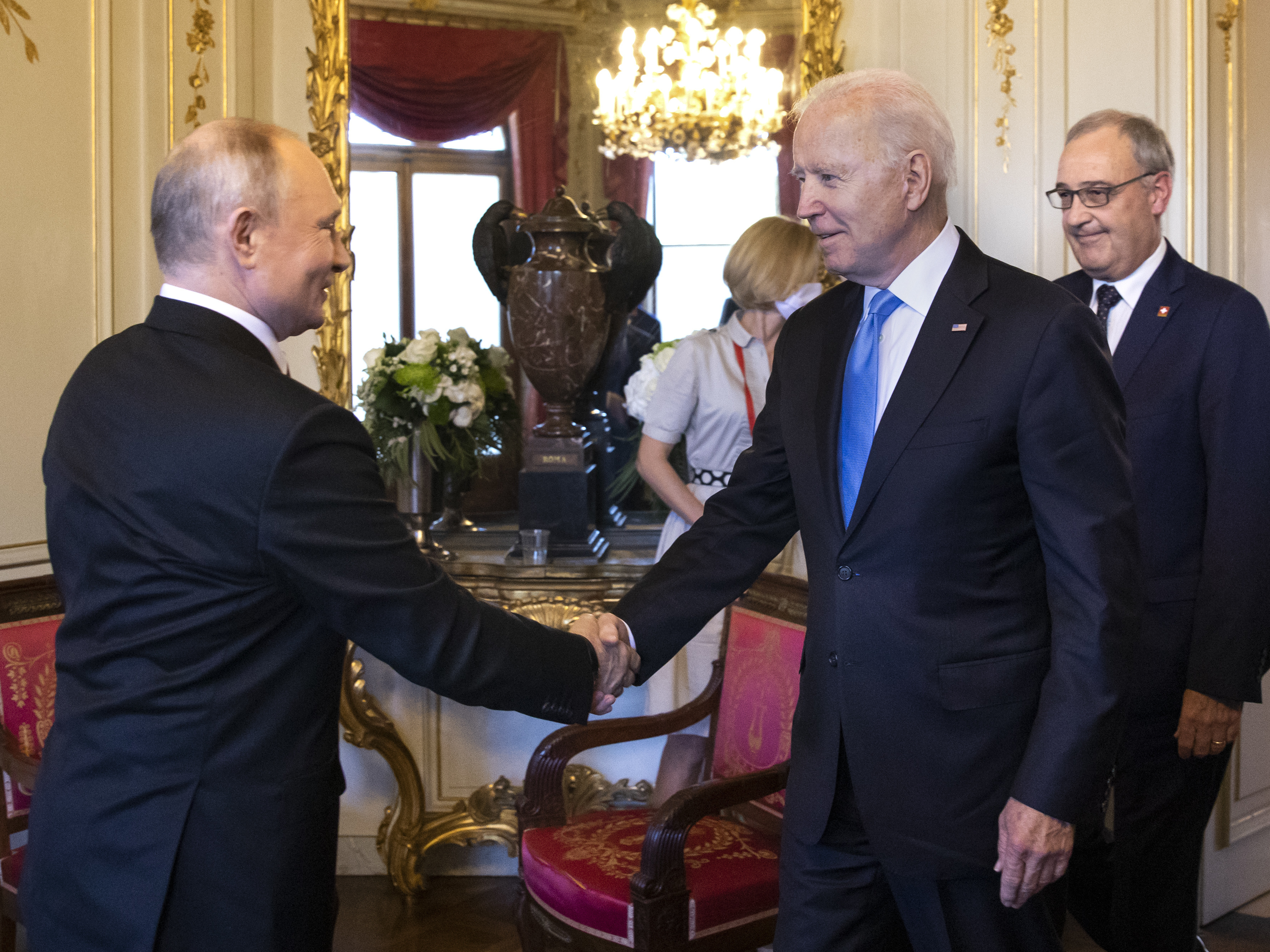 caption: U.S. President Biden and Russian President Vladimir Putin shake hands as Swiss President Guy Parmelin (right) looks on during the U.S.-Russia summit at Villa La Grange on June 16 in Geneva, Switzerland.