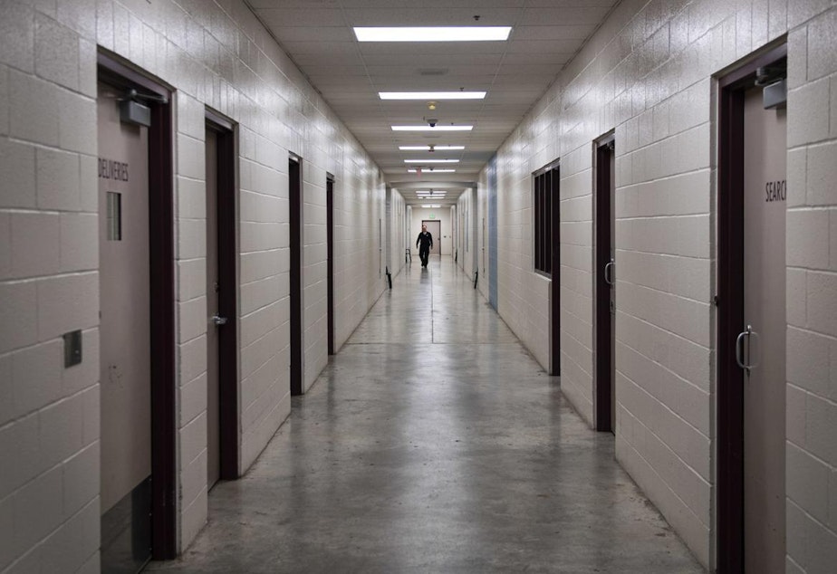 caption: A juvenile detention officer walks down a hall at the Cowlitz County Youth Services Center. 
