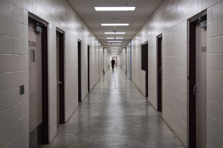 caption: A juvenile detention officer walks down a hall at the Cowlitz County Youth Services Center. 
