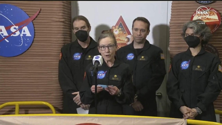 caption: In this image made from video provided by NASA, Kelly Haston, a crew member of the first CHAPEA mission, speaks in front of other members, from left to right, Ross Brockwell, Nathan Jones, and Anca Selariu, Saturday, July 6, 2024, at Johnson Space Center in Houston, Texas. The crew of a NASA mission to Mars emerged from their craft after a yearlong voyage that never left Earth. The four volunteers crew members spent more than 12 months inside NASA's first simulated Mars environment at Johnson Space Center i
