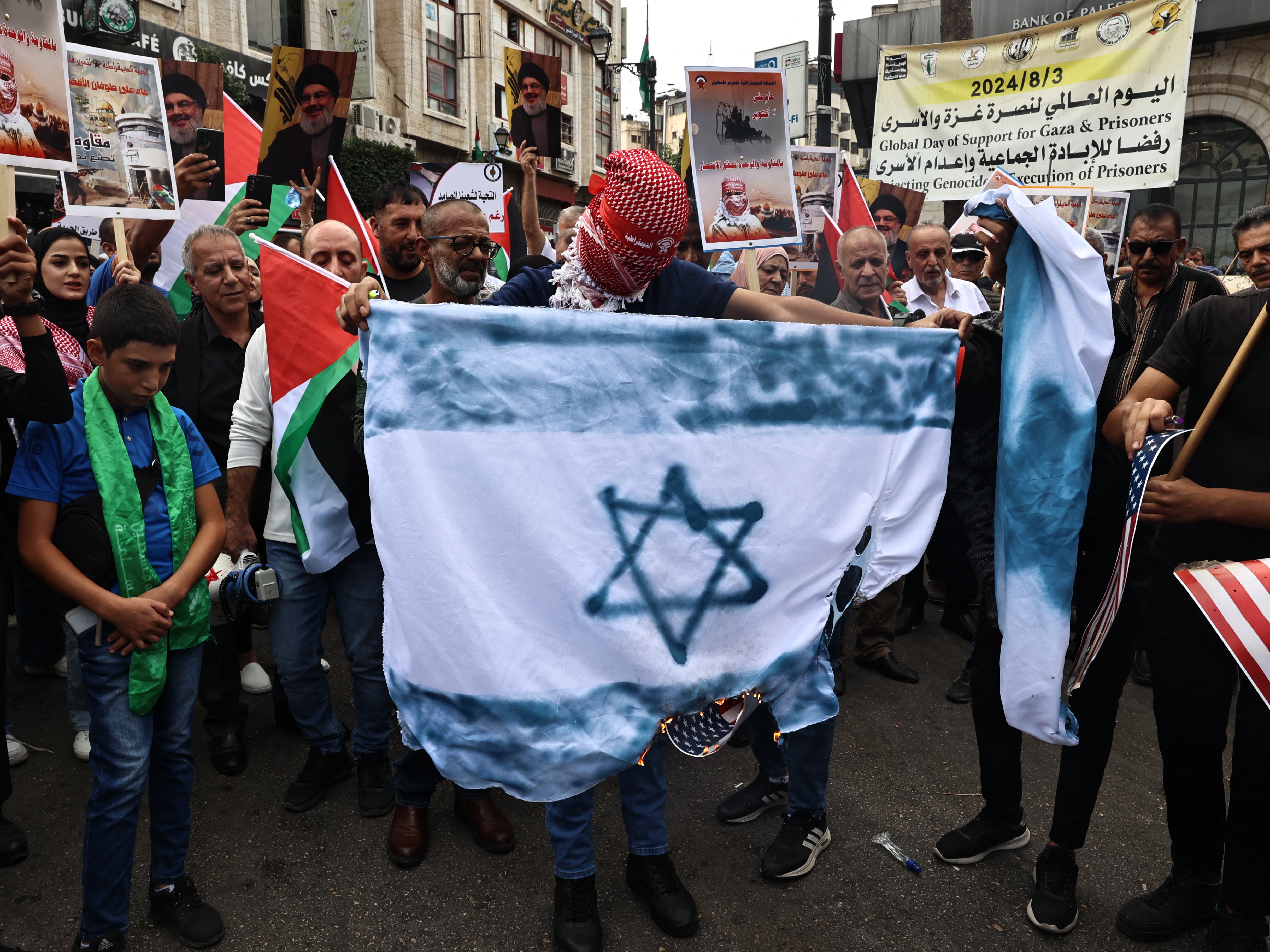 caption: Palestinian protesters attend a rally to mark the first anniversary of Palestinian militant group Hamas' Oct. 7, 2023, attack on Israel, in Ramallah in the occupied West Bank on Monday.