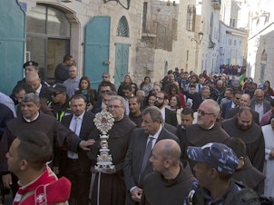 caption: Clergymen carry a wooden relic believed to be from Jesus' manger outside the Church of the Nativity, traditionally believed by Christians to be the birthplace of Jesus Christ, in the West Bank city of Bethlehem, on Saturday.