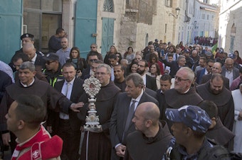 caption: Clergymen carry a wooden relic believed to be from Jesus' manger outside the Church of the Nativity, traditionally believed by Christians to be the birthplace of Jesus Christ, in the West Bank city of Bethlehem, on Saturday.