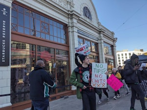caption: Workers picket outside the Starbucks Reserve Roastery in Seattle's Capitol Hill neighborhood.