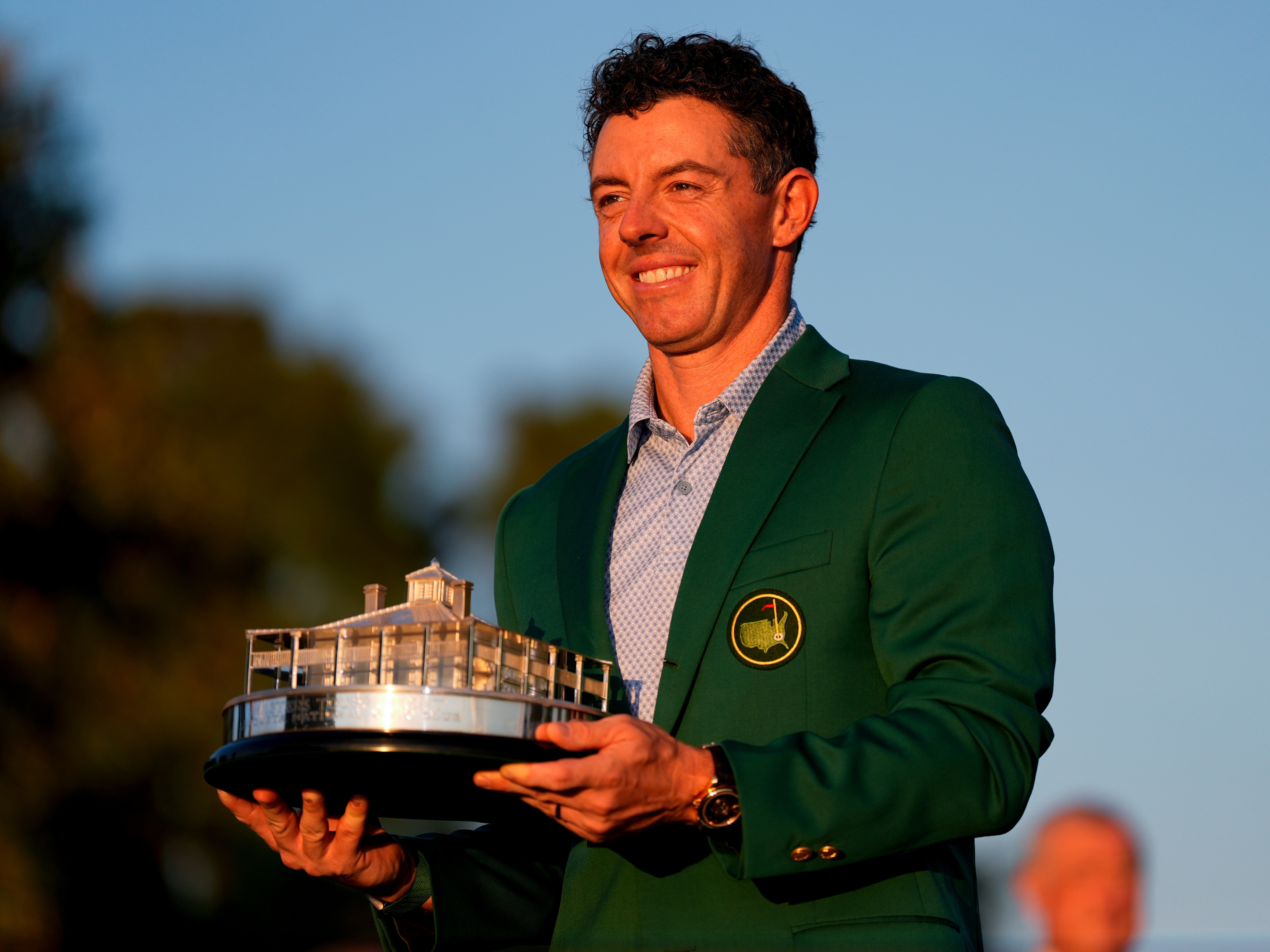 caption: Rory McIlroy, of Northern Ireland, holds the trophy after winning the Masters golf tournament at the Augusta National Golf Club, Sunday, April 12, 2026, in Augusta, Ga.
