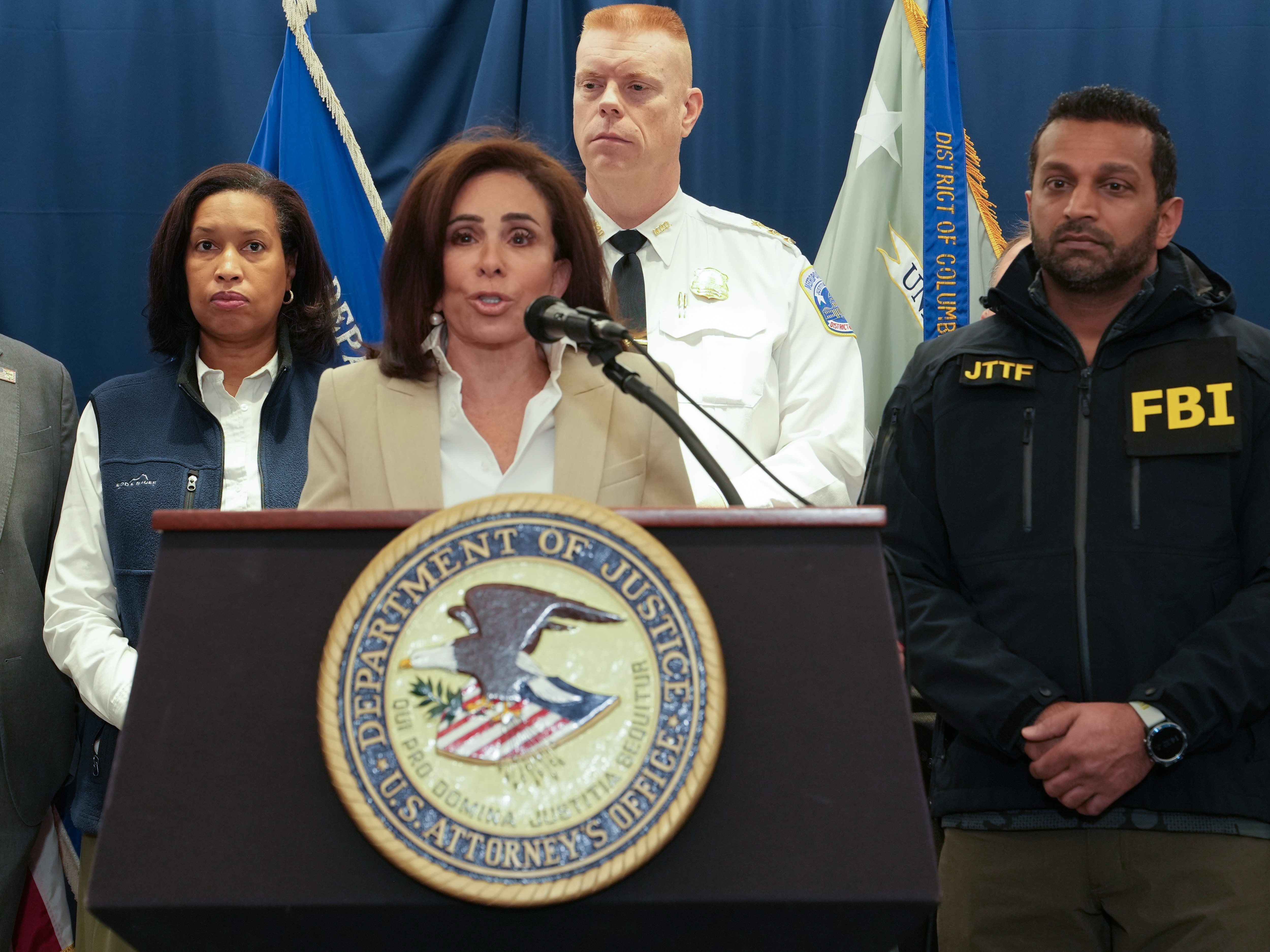 caption: U.S. Attorney for the District of Columbia Jeanine Pirro speaks to the press Thursday about the investigation into the shooting of two West Virginia National Guard members. Looking on are Washington, D.C., Mayor Muriel Bowser (from left), D.C. Executive Assistant Police Chief Jeffery Carroll and FBI Director Kash Patel.