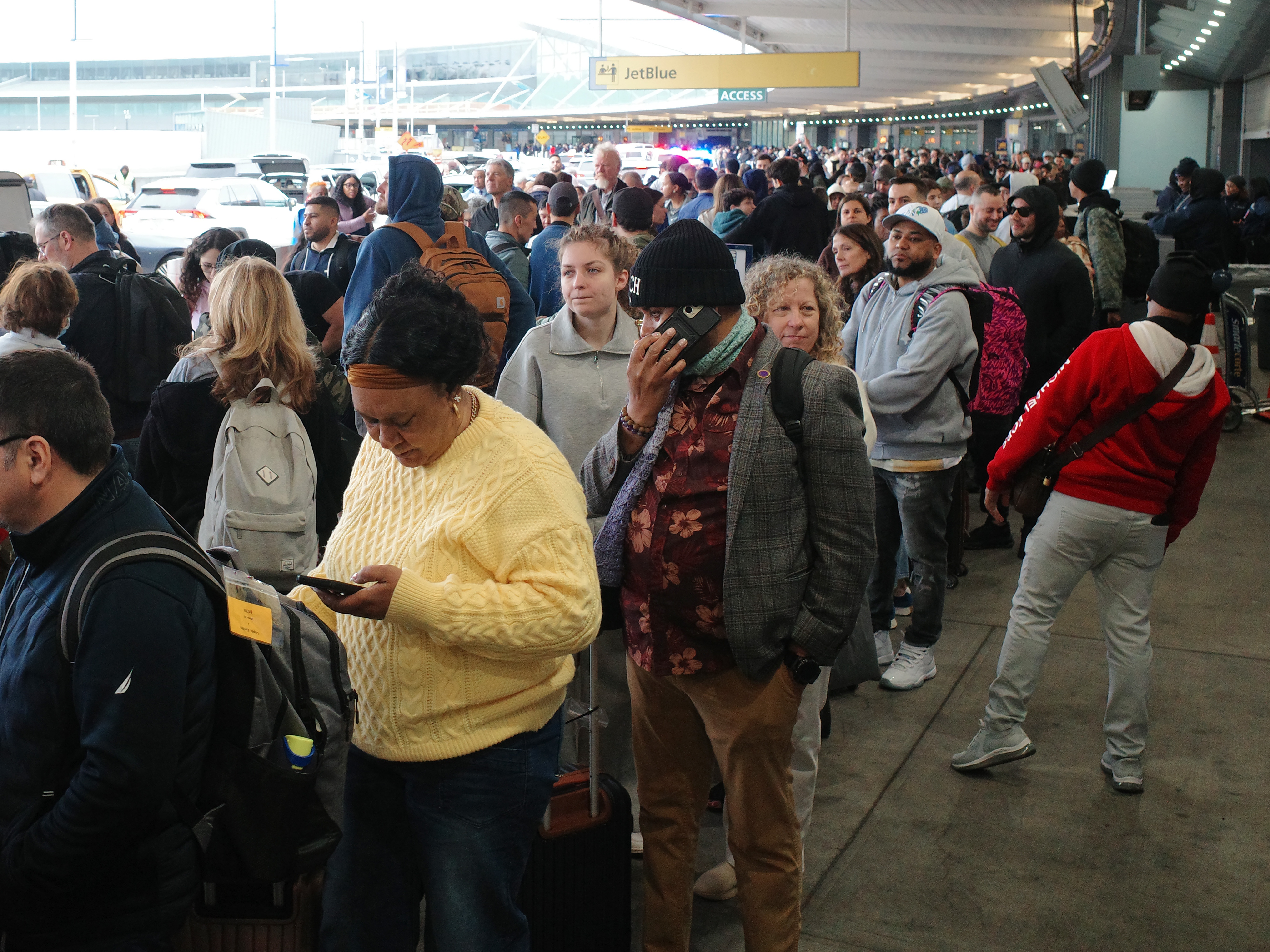 caption: Travelers wait in line to go through TSA screening in Terminal 5 at John F. Kennedy International Airport on Friday in New York. The partial government shutdown has brought the longest TSA wait times in history, forcing some airline customers to rebook flights missed due to airport delays.