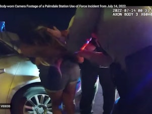 caption: A year later, the Los Angeles County Sheriff's Department has released body-worn camera footage of a July 13, 2022, incident in which one of several deputies arresting a woman at a traffic stop punched her in the face as she held her newborn baby.