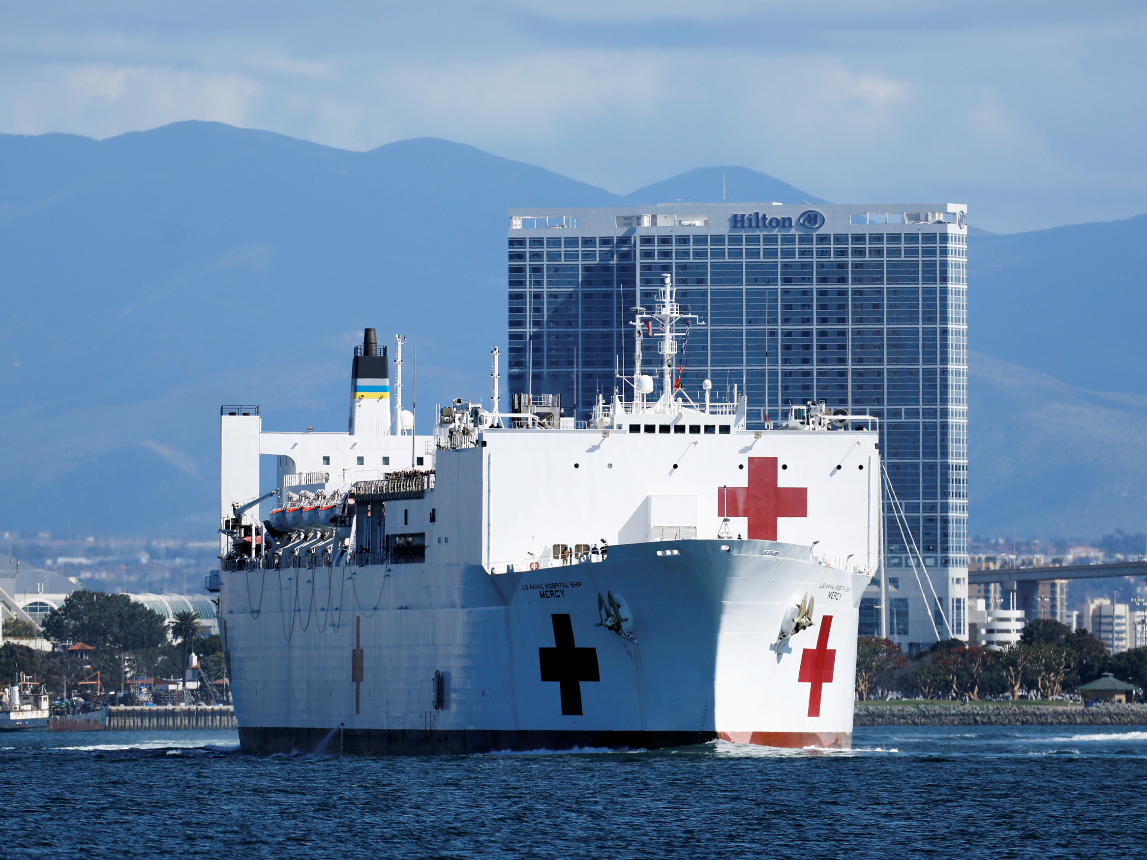 caption: Navy medical and support personnel staff the USNS Mercy, but the hospital ship belongs to the Navy's Military Sealift Command and is run by a crew of civilian mariners. The ship headed to the Port of Los Angeles on March 23 in response to the coronavirus pandemic.