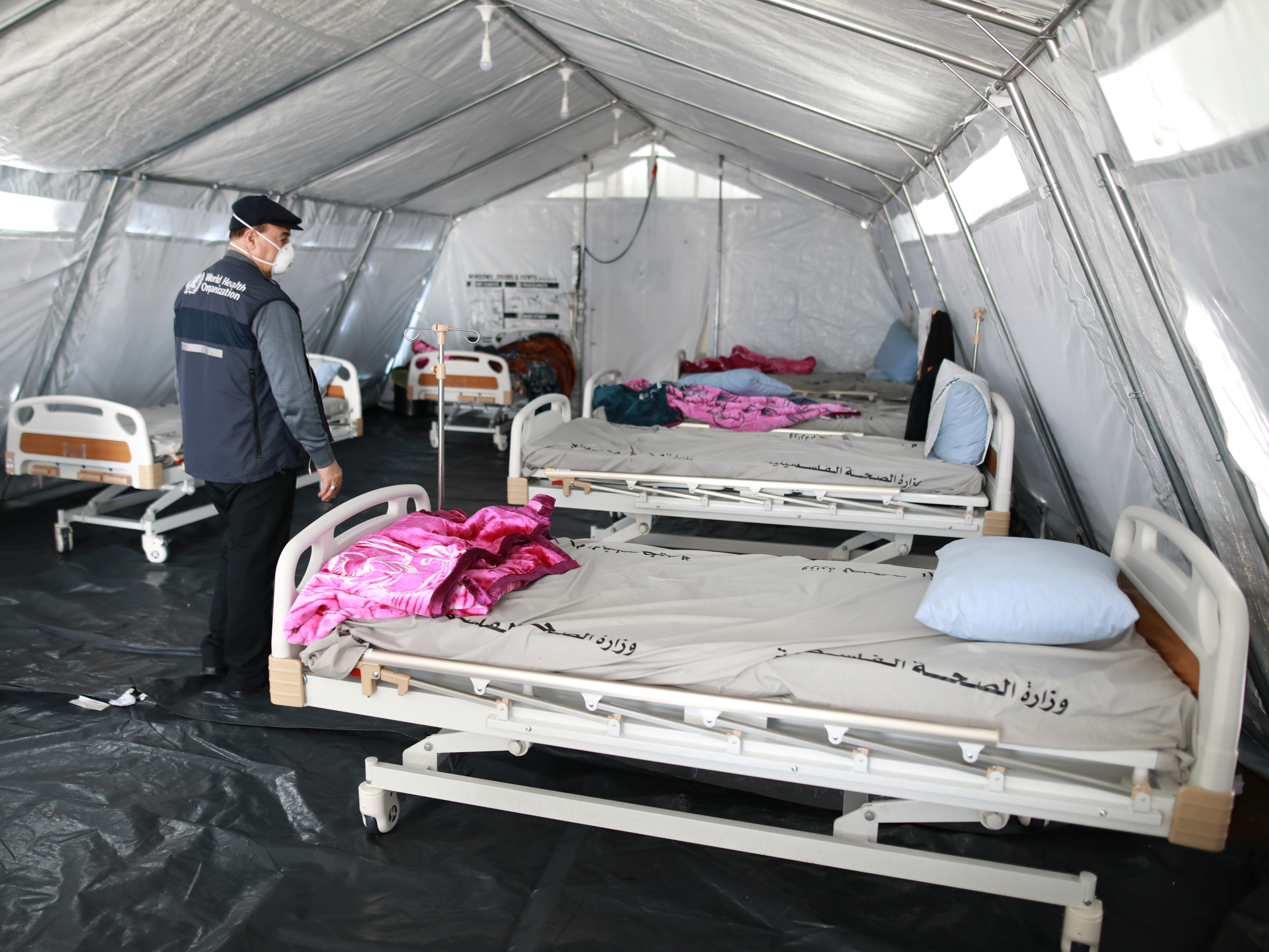 caption: The World Health Organization is is "absolutely critical to the world's efforts to win the war against COVID-19," U.N. Secretary-General António Guterres said, after President Trump said he will halt funding to the agency. Here, a WHO staff member inspects a coronaviruus quarantine facility at the Rafah border crossing in the southern Gaza Strip in March.