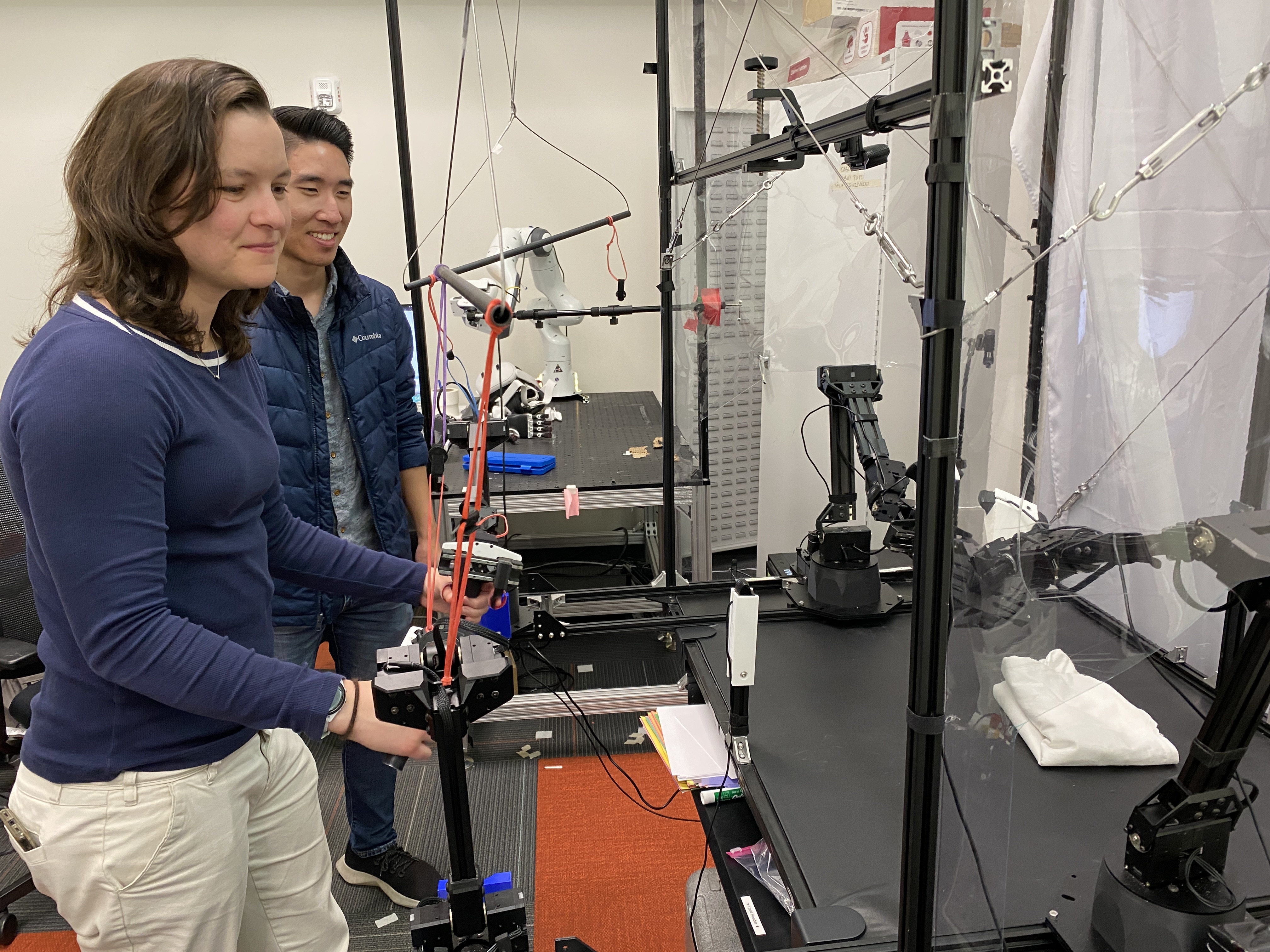 caption: Chelsea Finn (left) and Moo Jin Kim conduct a demonstration with a robot at Stanford University.