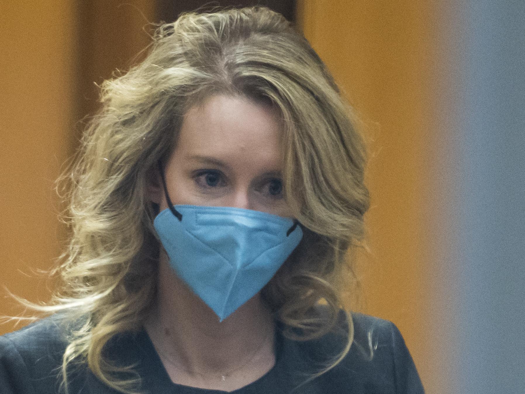 caption: Elizabeth Holmes walks into federal court in San Jose, Calif., in January 2022.