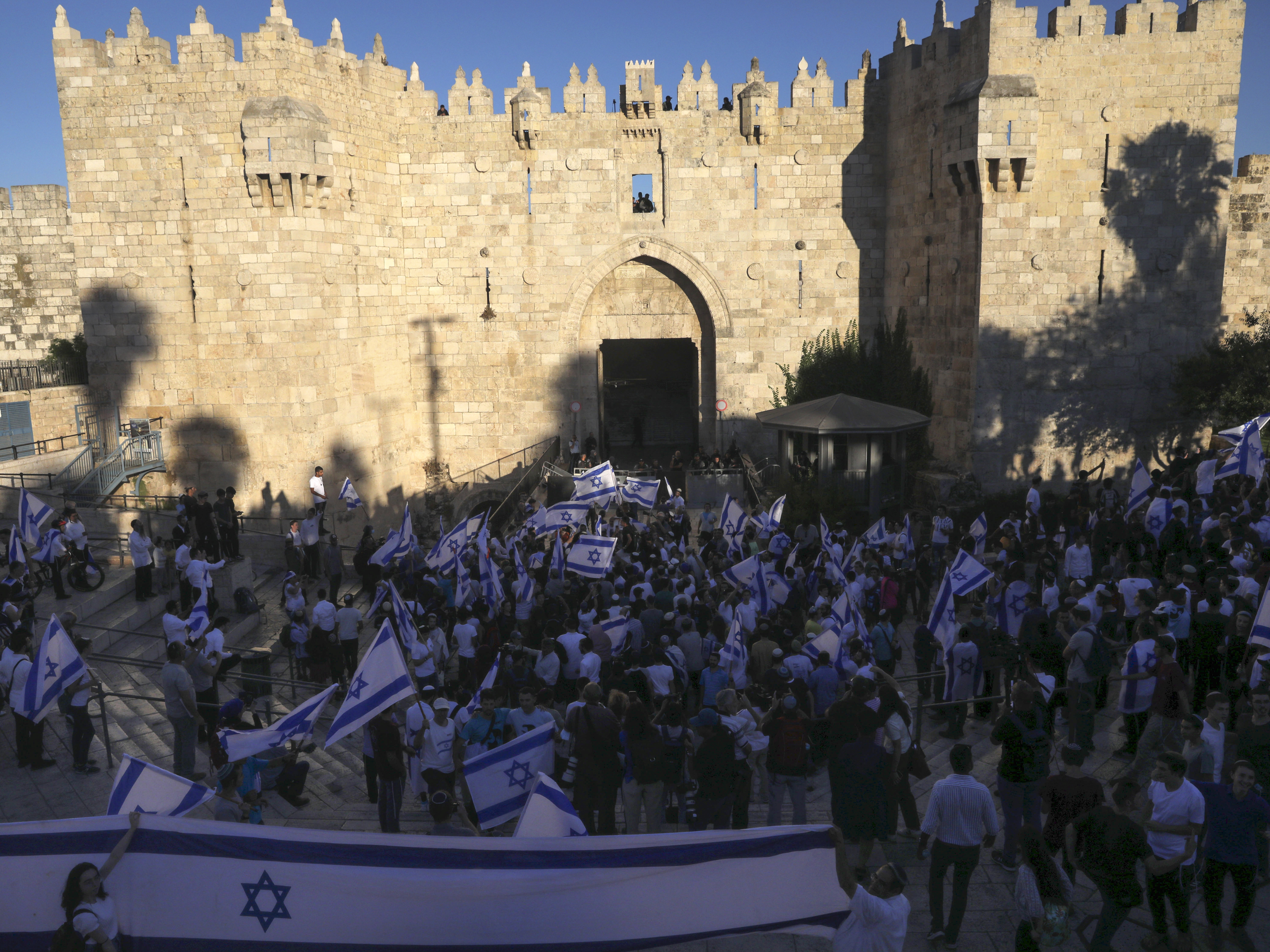 caption: Jewish ultranationalists take part in a flag-waving march Tuesday next to the Damascus Gate, outside Jerusalem's Old City.