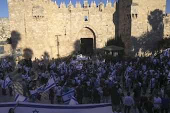 caption: Jewish ultranationalists take part in a flag-waving march Tuesday next to the Damascus Gate, outside Jerusalem's Old City.
