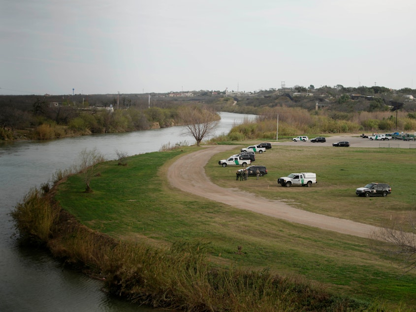 caption: U.S. Border Patrol cars are seen from the bridge connecting Eagle Pass, Texas, with Piedras Negras, Mexico, near the banks of the Rio Grande in February.