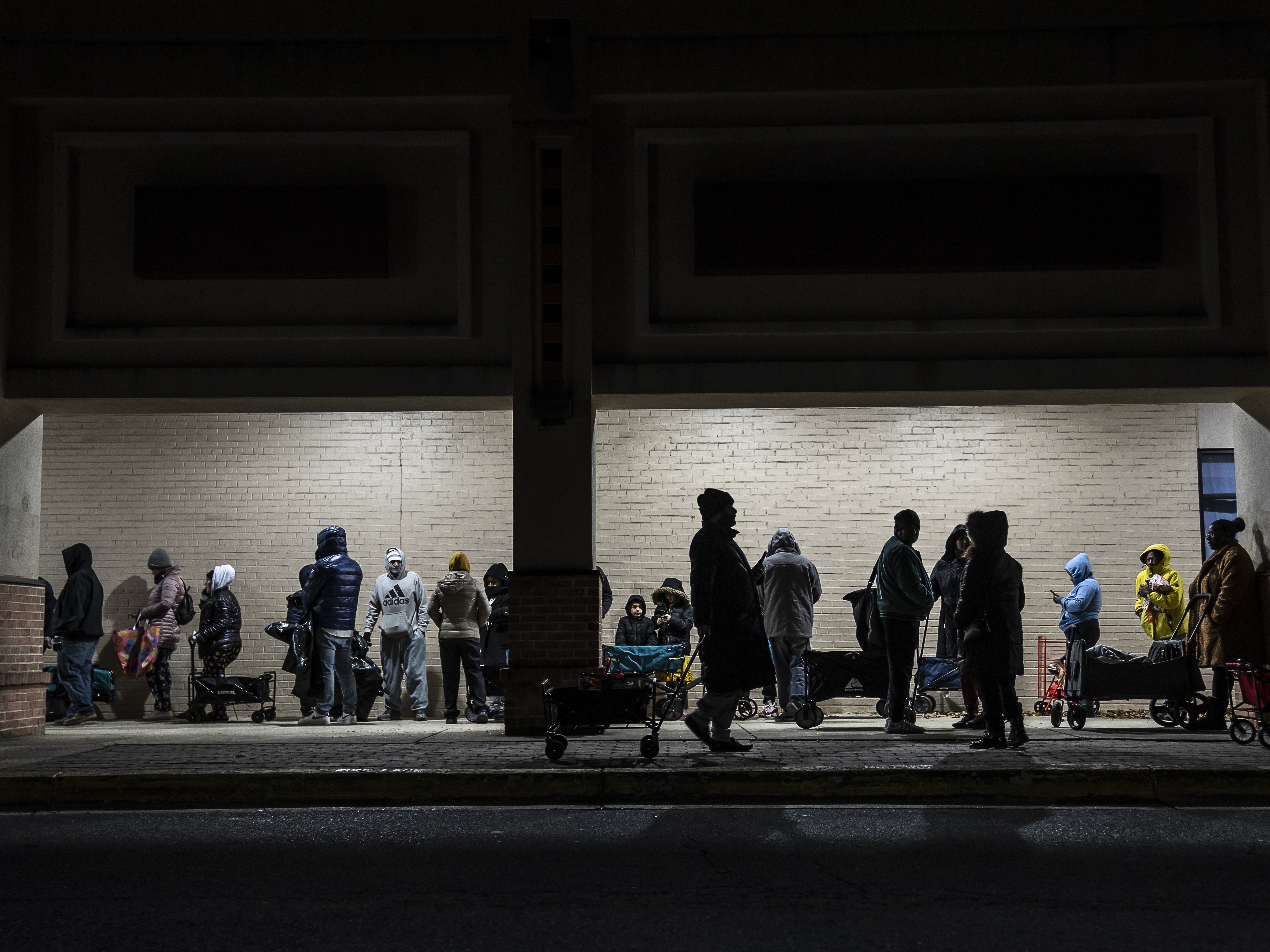 caption: At the No Limits food pantry in Landover, Md., the line of people waiting to get in on Dec. 6, 2024, stretches to the street and down the block.
