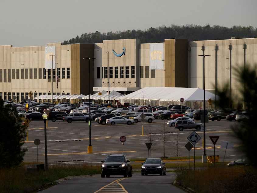 caption: Signs reading "vote" hang outside the Amazon warehouse in Bessemer, Ala., in March as workers wrapped up their seven-week mail-in election on whether to unionize.