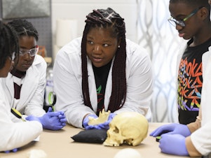 caption: Using a plastic skull, archaeologist Alicia Odewale teaches a lesson about Tulsa's ongoing search for mass graves containing victims of the city's 1921 race massacre. She taught it at Black History Saturdays, a free private program designed for students to learn unvarnished lessons in African-American history that teachers say a new law targeting race education has made harder to honestly teach.