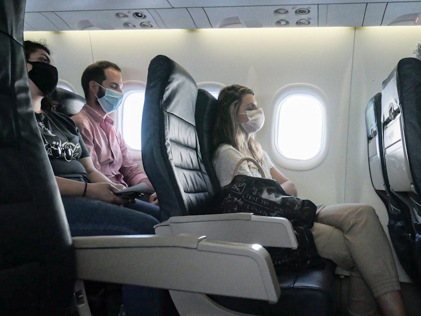 caption: Many airlines now require passengers to wear masks to reduce the risk of COVID-19 spread — and are putting scofflaws on a no-fly list.