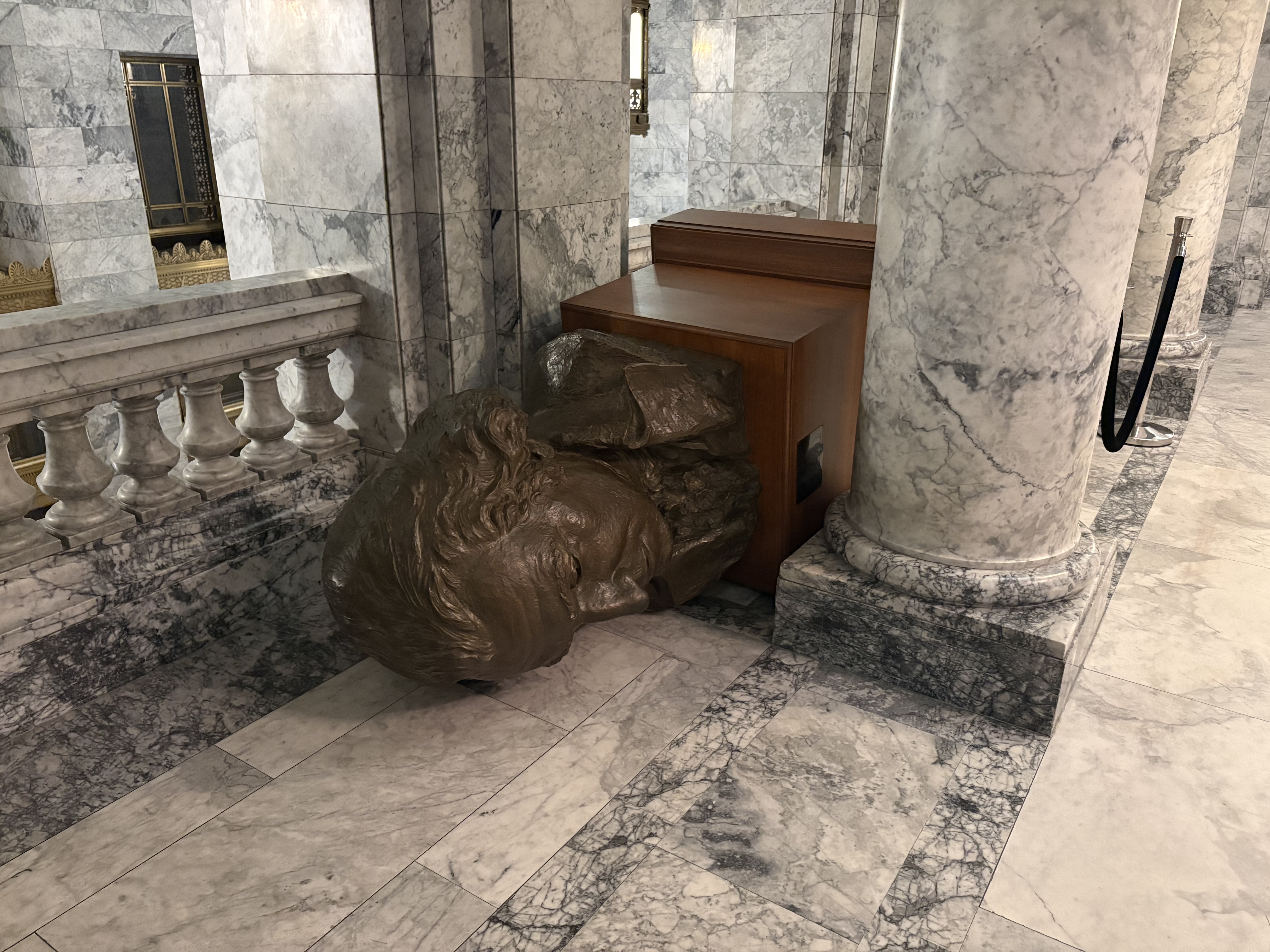 caption: A larger-than-life-sized bust of George Washington in the state Capitol, knocked over by an intruder on Oct. 5, 2025.