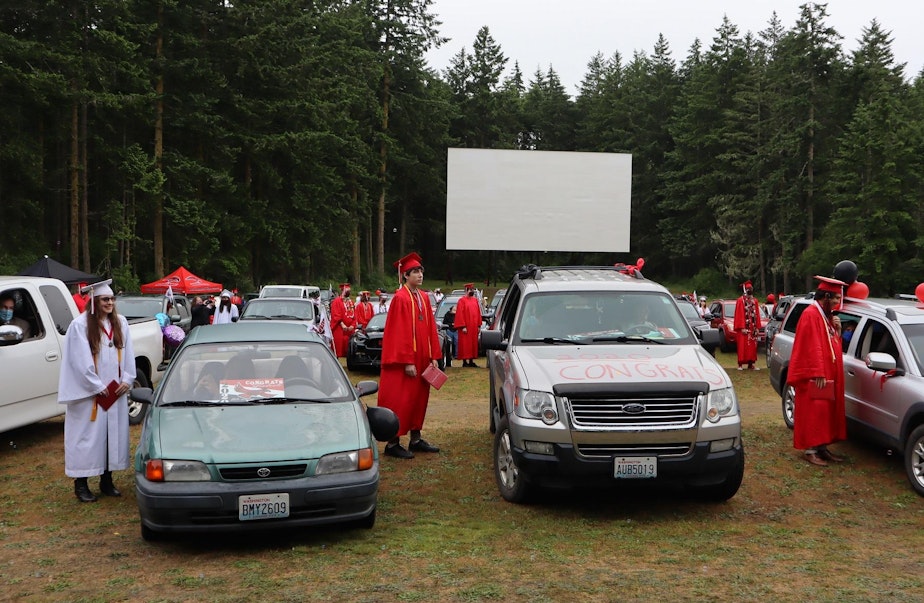 caption: Port Townsend High School seniors looked to a temporary stage near the back of the drive-in theater, rather than toward the big screen, during their graduation on June 12, 2020.